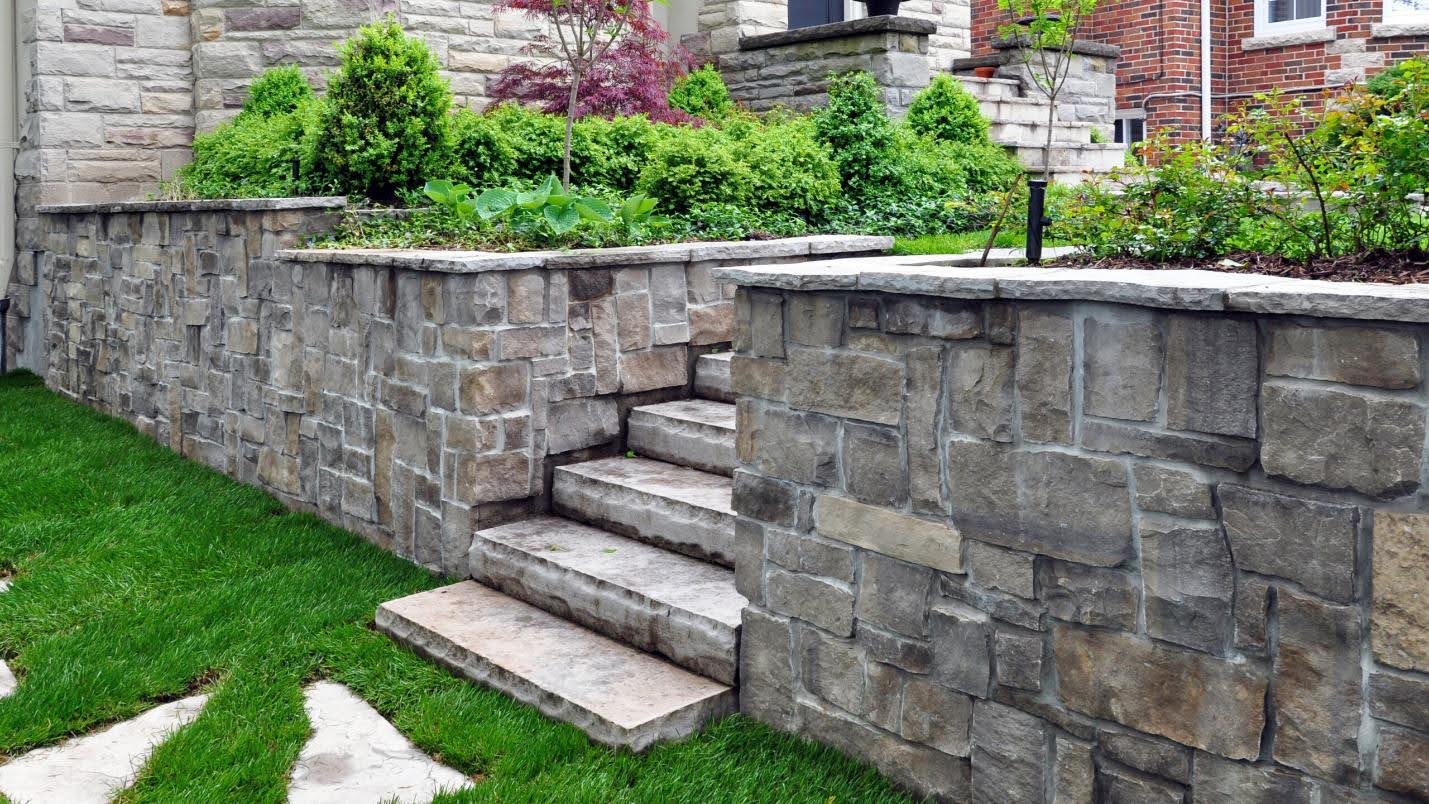 Finished natural boulder retaining wall on a Blackstone Landscaping Southeast Michigan project